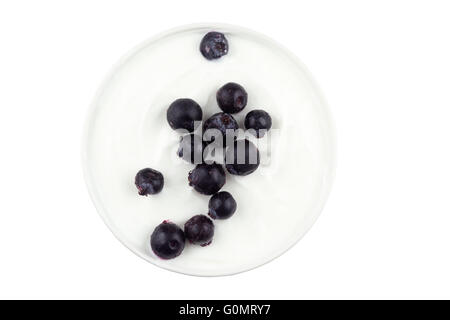 Bacche di Saskatoon cosparse in una ciotola di yogurt greco su fondo bianco. Conosciuto anche come Junebries. Foto Stock