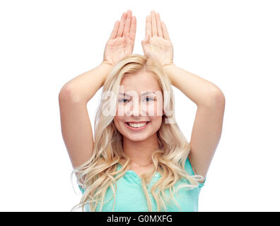 Sorridenti giovane donna fare orecchie di coniglietto Foto Stock