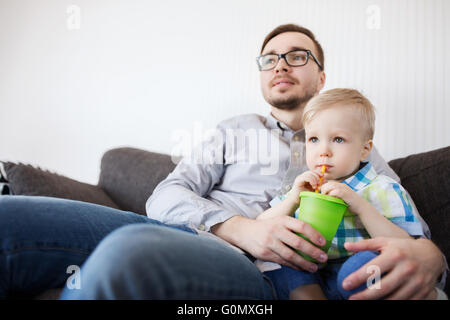 Padre e figlio di bere dalla tazza e a casa Foto Stock