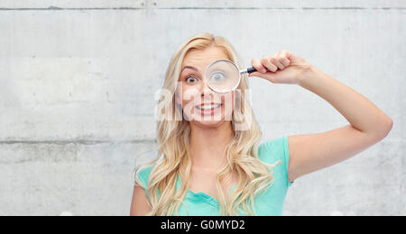 Felice giovane donna con lente di ingrandimento Foto Stock