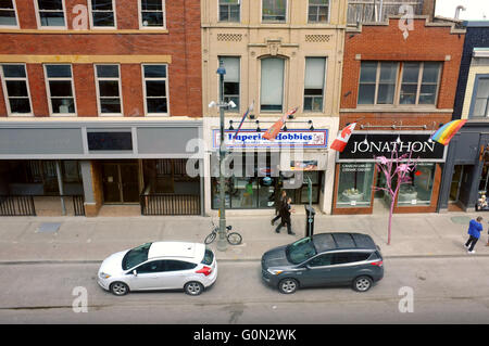 I pedoni a piedi dopo una fila di negozi nel centro cittadino della città canadese di London Ontario. Foto Stock