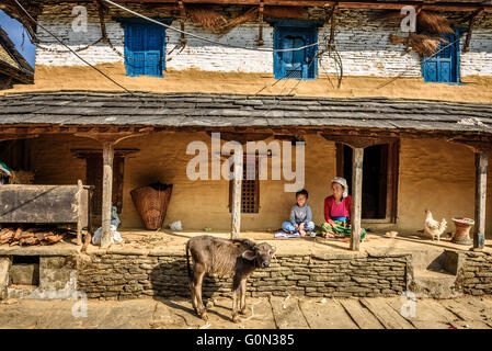 L'agricoltore nepalese donna con suo figlio nel cortile della sua casa colonica Foto Stock