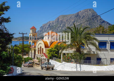 Dal tetto arancione chiesa greco ortodossa con Palm tree, pareti bianche e blu cielo Foto Stock