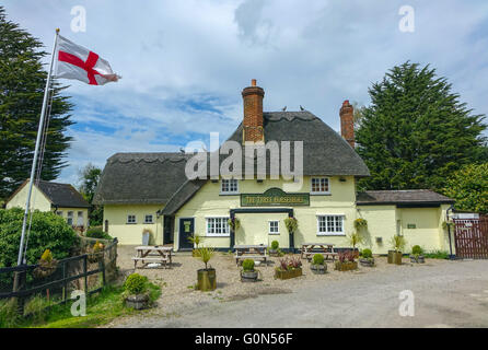 Tre pattini del cavallo pub con il tetto di paglia, vicino l'aeroporto di Stansted, Essex, con l'inglese St George bandiera Foto Stock