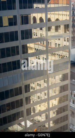 La facciata della Federal Reserve Bank di New York sulla costruzione Liberty Street in Lower Manhattan a New York è riflessa nel vetro di un edificio per uffici di Sabato, 30 aprile 2016. L'edificio è costruito in stile neo-rinascimentale, imitando un palazzo fiorentino, utilizzando bugnato di pietra calcarea e di arenaria sulla sua facciata. Costruito tra il 1919-24 e progettato dalla società di York e Sawyer. (© Richard B. Levine) Foto Stock