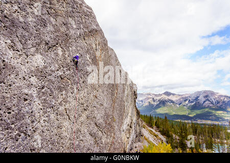 Gli alpinisti praticare il loro rock climbing competenze sulle ripide pareti di roccia delle montagne a grassi laghi vicino a Canmore in Alberta, Canada Foto Stock