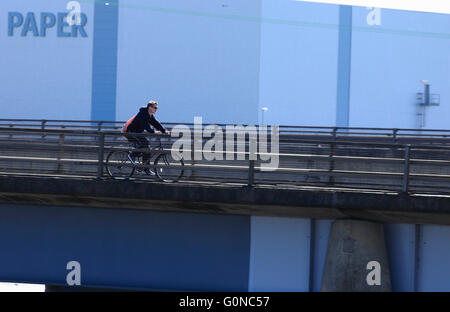 Giovane maschio ciclista su un ponte nella parte anteriore del Palm fabbrica di carta in King's Lynn, Norfolk, Regno Unito. Foto Stock