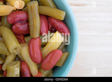 Inizio Chiudi vista di tre insalata di fagioli in una piccola ciotola in cima a una tavola di legno alto. Foto Stock