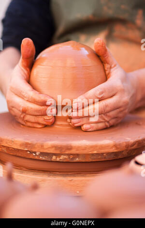 Il potter mani sagomatura di argilla sul tornio a Valencia. Foto Stock