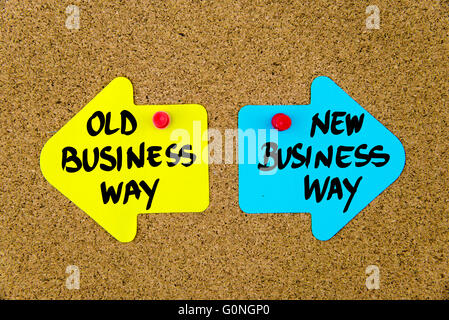 Messaggio vecchio modo di business rispetto al nuovo modo di business su giallo e blu note di carta come frecce opposte imperniata sulla bacheca di sughero con thumbtacks. Scelta immagine concettuale Foto Stock
