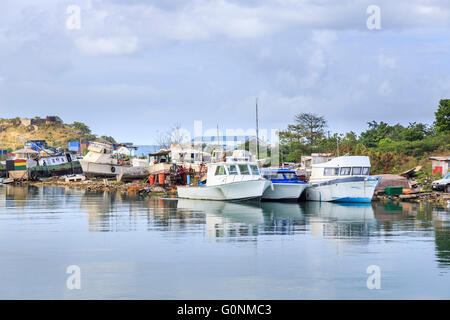 Vecchio locale barche da lavoro a galla e spiaggiata in un cantiere nel porto di St John's, a nord di Antigua e Barbuda, Antille Foto Stock