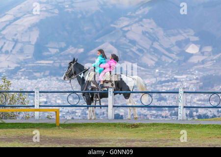 QUITO, ECUADOR, ottobre - 2015 - Due indigeni ragazze ecuadoriane in sella ad un cavallo a Panecillo Hill a Quito, Ecuador Foto Stock