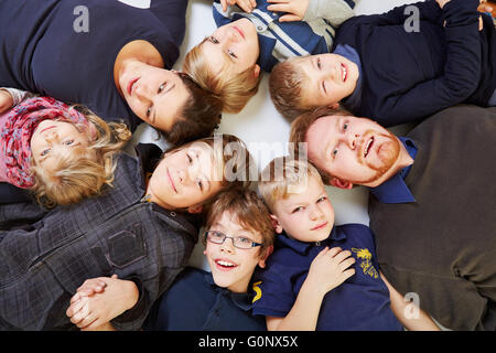 La grande famiglia con sei bambini in un cerchio cercando Foto Stock