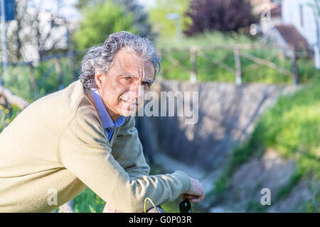 Uomo di mezza età in azzurro camicia e maglione giallo nella campagna di Emilia Romagna Foto Stock