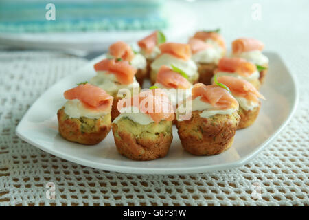 Gli spinaci fatti in casa mini muffin con crema di formaggio e salmone affumicato su bianco piatto Foto Stock