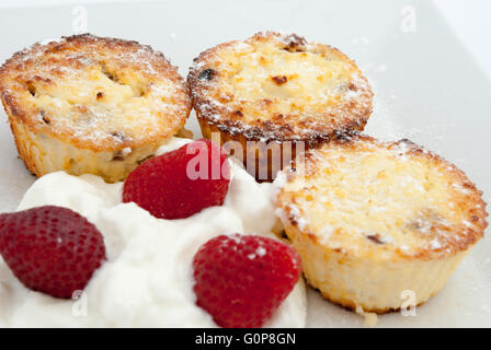 Cottage cheese syrniki, cotto come tortine o muffin, servita con yogurt e fragole sulla piastra bianca closeup. Foto Stock