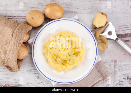 Purè di patate su piastra, mature le patate in una sacca di tela in background. Potatoe culinaria mangiare. Foto Stock