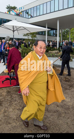 Bad Saarow, Germania. 04 Maggio, 2016. Sogyal Rinpoche, Tibetano Meditazione master e maestro della tradizione Nyingma del buddhismo tibetano, passeggiate attraverso il sito in apertura di Sukhavati spirituale Centro di cura a Bad Saarow, Germania, 04 maggio 2016. Il 'Sukhavati' centro buddista sarà aperto il Mercoledì con una benedizione cerimoniale da studioso Sogyal Rinpoche. Il bianco edificio complesso è costruito su un 8.000 metri quadrati sul sito Scharmuetzel lago nel centro della città. Foto: PATRICK PLEUL/dpa/Alamy Live News Foto Stock