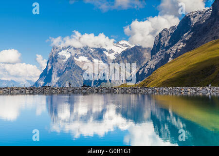 Splendida vista del Wetterhorn con la riflessione in un bellissimo stagno sul Oberland Bernese su una soleggiata giornata estiva, Svizzera. Foto Stock