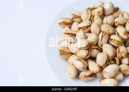 Vista ravvicinata di pistacchi tostati semi con guscio nel piatto piccolo. Foto Stock