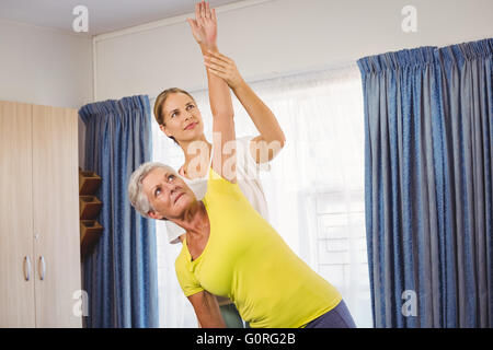 Un istruttore di fitness aiutando senior facendo esercizi Foto Stock