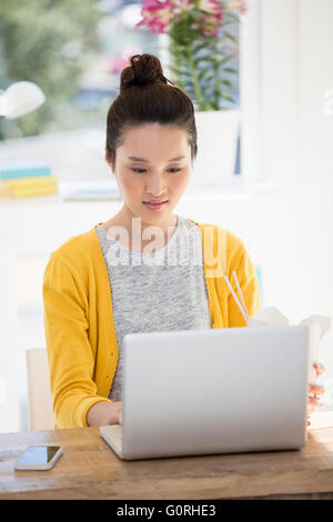 Un business donna sta lavorando sul suo computer portatile Foto Stock