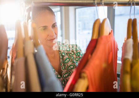 Donna selezionando un abbigliamento mentre lo shopping per i vestiti Foto Stock