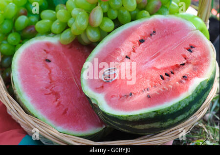 Due anelli di nozze su metà un cocomero. Foto Stock