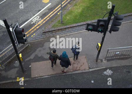 Famiglia immigrata sul marciapiede vicino al semaforo di Glasgow, Scozia Foto Stock