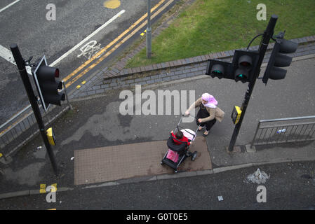 Famiglia immigrata sul marciapiede vicino al semaforo di Glasgow, Scozia Foto Stock