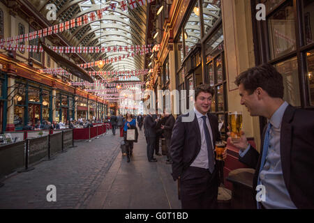 City of London, Londra, Inghilterra, Regno Unito. 19 aprile 2016 tipi di città di bere a pranzo nel mercato Leadenhall. Mercato Leadenhall è un mercato coperto di Londra, situato su Gracechurch Street ma con accesso veicolare disponibile anche via Whittington Avenue a nord e Lime Street a sud e a est, e ulteriore accesso pedonale tramite un certo numero di passaggi stretti. Si tratta di uno dei più antichi mercati di Londra, risalente al XIV secolo e si trova nel centro storico della città di Londra il quartiere finanziario. Foto Stock