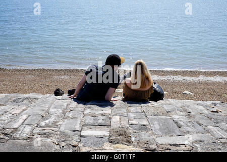 Coppia giovane seduto sul lungomare southsea England Regno Unito Foto Stock