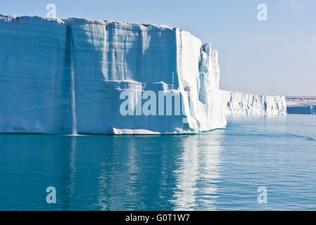 Una cascata proveniente da sopra il ghiaccio a strapiombo sul bordo della calotta glaciale a Brasvellbreen su Austfonna in Svalbard Foto Stock