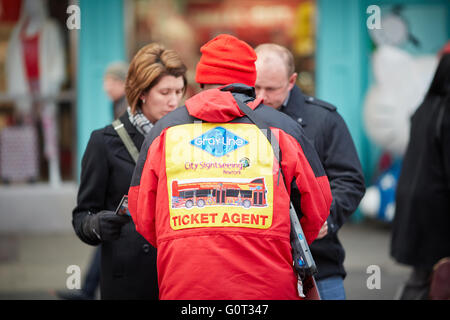 New York Times Square rosso vendita uniforme hop on off biglietti autobus temolo rappresentante Coach tours venditore con segno arresto Foto Stock