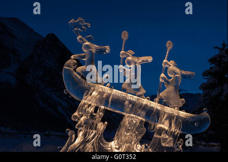 Sculture di ghiaccio delle popolazioni indigene in una canoa, Lago Louise, il Parco Nazionale di Banff, Alberta, Canada Foto Stock