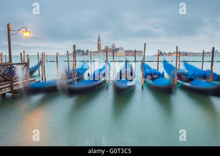 Gondole e la chiesa di San Giorgio Maggiore, al tramonto, Venezia, Italia Foto Stock