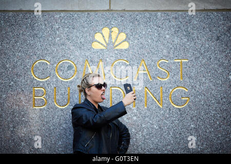 New York il dettaglio di entrata a 30 Rockefeller Plaza centro Rockefeller Center persona tenendo selfie a Comcast edificio si Foto Stock