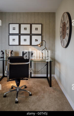 Visualizza home studio interno ufficio portatile scrivania in vetro orologio sulla parete crema adulti stampa scura sfondo spazio calmo Suburban su Foto Stock