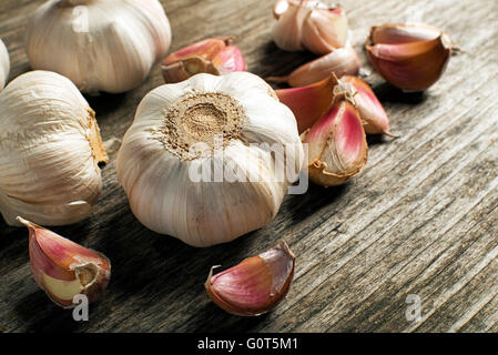 Spicchi di aglio su sfondo di legno vicino. Foto Stock