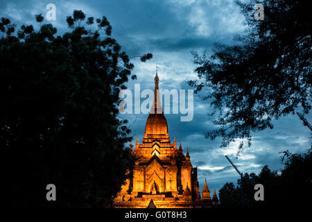 BAGAN, Myanmar - la Pagoda di Dhammayazika si staglia contro il cielo oscuro al crepuscolo a Bagan. Costruita nel 1196 dal re Narapatisithu, questa pagoda a base circolare con il suo caratteristico design pentagonale e la guglia dorata crea un contorno suggestivo mentre la luce del giorno svanisce. La forma unica della struttura contrasta con i tipici templi a base quadrata sparsi nell'antico paesaggio di Bagan. Foto Stock