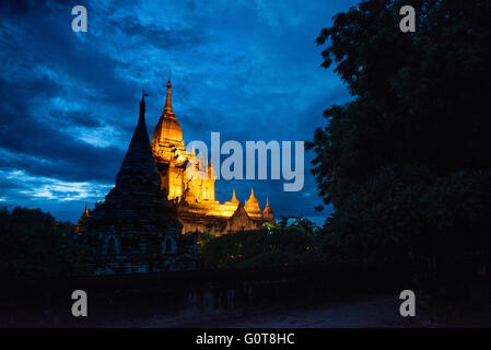 BAGAN, Myanmar - la Pagoda di Dhammayazika si staglia contro il cielo oscuro al crepuscolo a Bagan. Costruita nel 1196 dal re Narapatisithu, questa pagoda a base circolare con il suo caratteristico design pentagonale e la guglia dorata crea un contorno suggestivo mentre la luce del giorno svanisce. La forma unica della struttura contrasta con i tipici templi a base quadrata sparsi nell'antico paesaggio di Bagan. Foto Stock