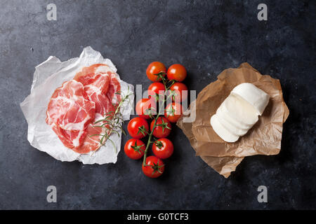 Il prosciutto, mozzarella e pomodoro ciliegino su tavolo di pietra. Vista superiore Foto Stock