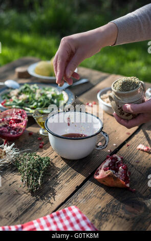 La donna la preparazione di condimento per insalata Foto Stock