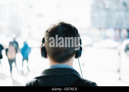 Vista posteriore del hipster uomo che indossa le cuffie Foto Stock