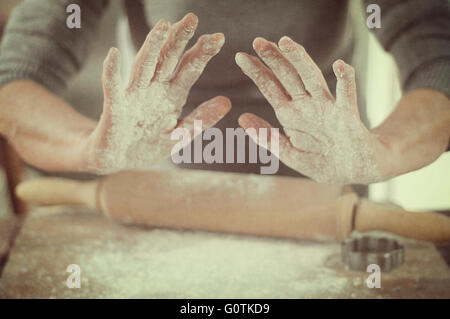 Donna con farina sulle sue mani usando il pin di laminazione Foto Stock