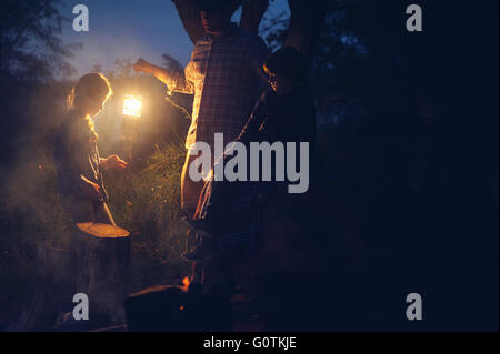 Uomo che tiene una lanterna mentre accampando con tre bambini, Texas, Stati Uniti Foto Stock