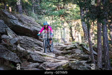 Donna in mountain bike nella foresta, Alto Adige, Italia Foto Stock