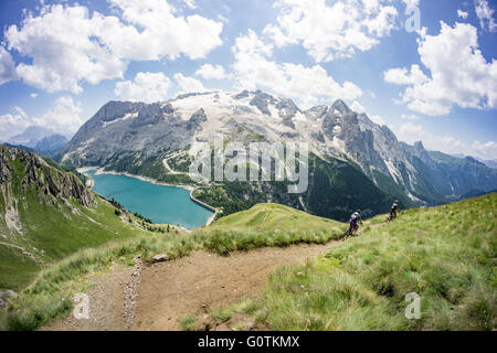 L uomo e la donna in mountain bike lungo il sentiero, Dolomiti, Italia Foto Stock