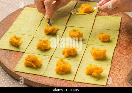 La donna la preparazione di zucca ripieni di pasta saccottini Foto Stock