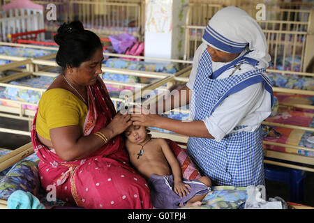 Teresa Suor cura un ragazzo malato nel 'Nirmala Shishu Bhawan Childrens Home' delle Missionarie della Carità (Madre Teresa sorelle) in Calcutta, India Foto Stock